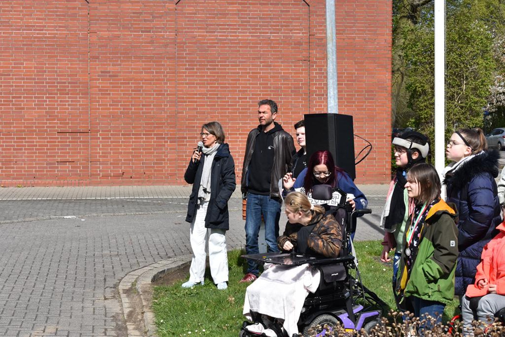 Die Schulleitung spricht durch ein Mikrofon.