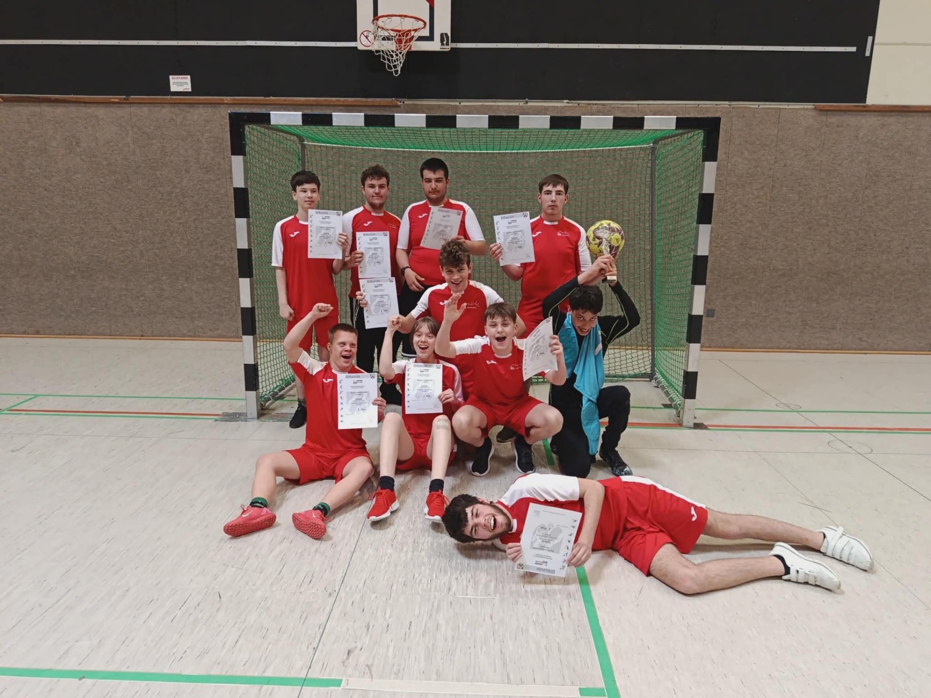 Die Spieler in roten Trikots vor dem Tor in der Halle.