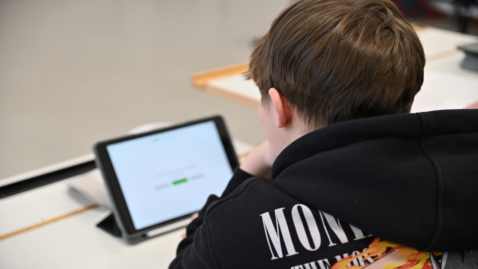 Fünf Jugendliche stehen im Freien vor einer Hecke und einem Baum.